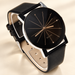 Black-dial wristwatch with black strap on ivory surface