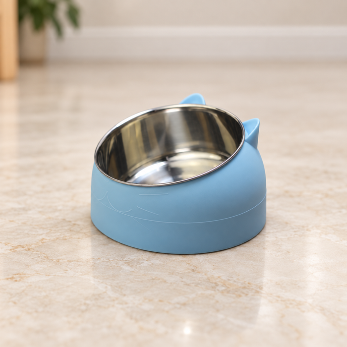 Blue cat-ear pet bowl with a tilted stainless steel insert on an ivory floor.
