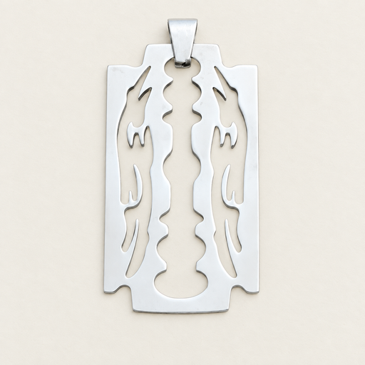 Silver blade-shaped decorative pendant without a chain, lying on an ivory surface.