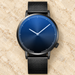 Black mesh-band watch with a blue dial on ivory stone