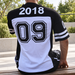 Black and white numbered jersey shown from behind on a seated model.