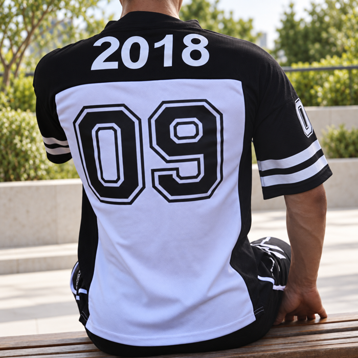 Black and white numbered jersey shown from behind on a seated model.