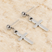 Silver cross drop stud earrings on ivory stone