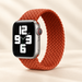 Orange braided watch strap on original grey watch against ivory background