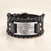 Black leather bracelet with silver eye plate on ivory tabletop