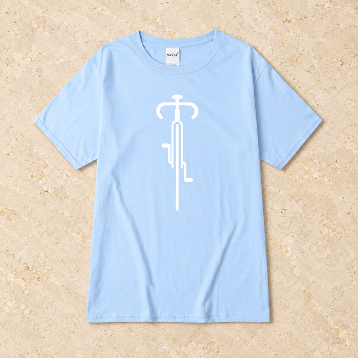 Pale blue short-sleeve T-shirt with a white bicycle graphic, laid flat on stone.
