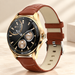Gold round watch with brown leather strap on ivory tabletop