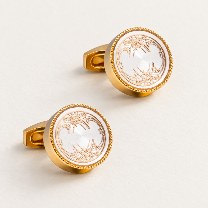 Pair of round gold-tone cufflinks with ornate white faces.