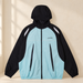 Mint and black hooded windbreaker against a warm ivory wall
