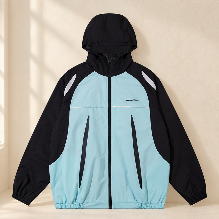 Mint and black hooded windbreaker against a warm ivory wall