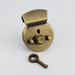 Brushed bronze bag lock and matching key on an ivory surface