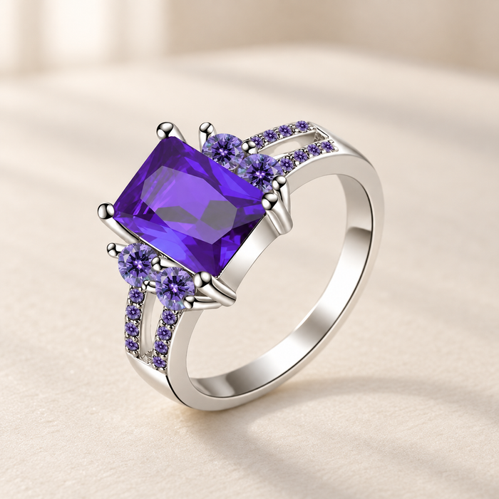 Silver tone ring with purple stones on ivory surface