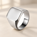 Plain silver tone signet ring on ivory tabletop