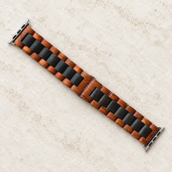 Wooden watch strap with dark central links on ivory stone.