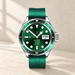 Green smart watch with silver case on an ivory surface.