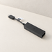 Black camera adapter with short USB cable on an ivory surface