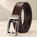 Coiled brown belt with rectangular silver buckle on a neutral surface.