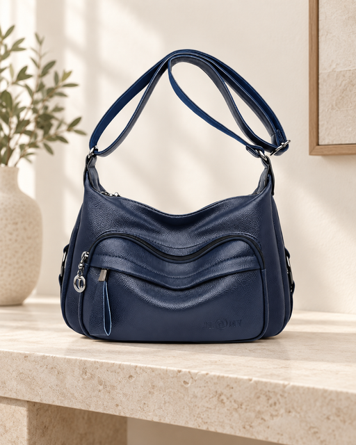 Navy blue shoulder handbag with curved front pockets, silver-tone zipper pulls and an adjustable strap.