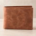 Tan brown bifold wallet with embossed B on a neutral surface.