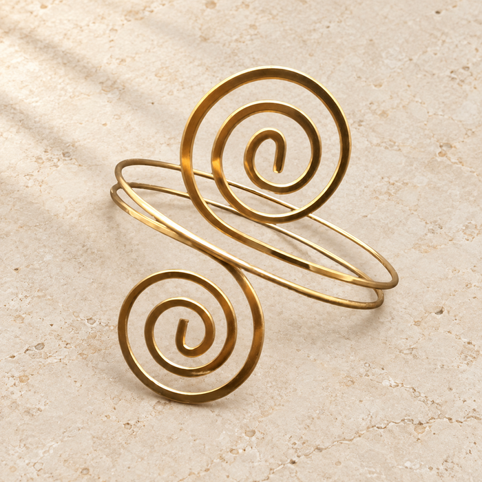 Gold-coloured spiral arm cuff on ivory stone