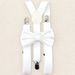 White suspenders and matching patterned bow tie arranged on ivory linen