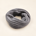 Grey knitted infinity scarf on ivory surface