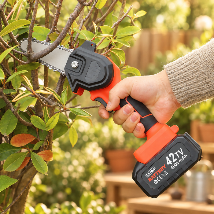 Orange compact saw held near a branch in warm garden light