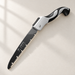 Open folding saw with black blade and silver and black handle on an ivory surface