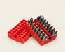 Specialty driver bits in an open red holder on an ivory surface