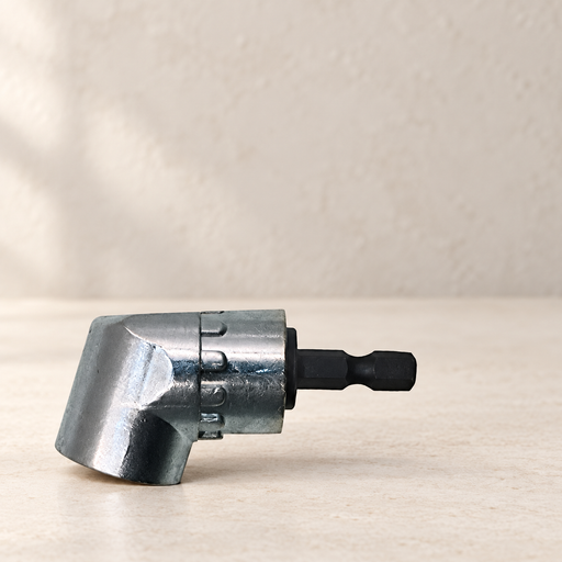 Silver right-angle screwdriver adapter with black hex shank on an ivory work surface