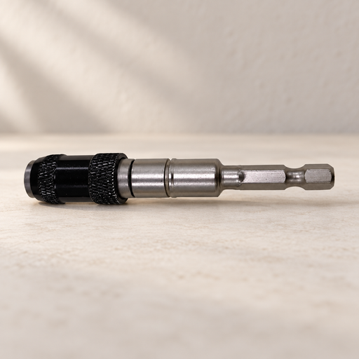 Silver and black screwdriver bit holder lying on a pale work surface