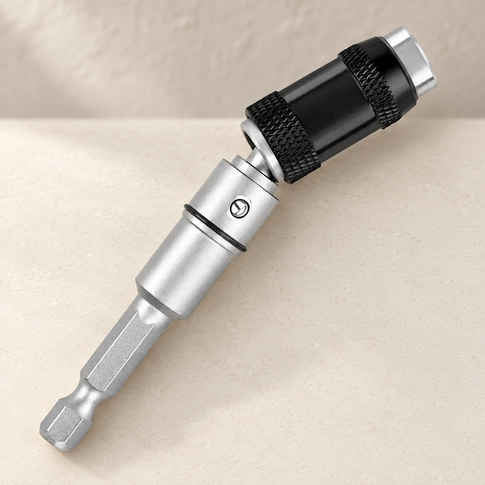 Silver magnetic screwdriver bit holder with black knurled collar on an ivory surface