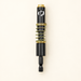 Black and gold spring-loaded hinge drill bit on ivory surface