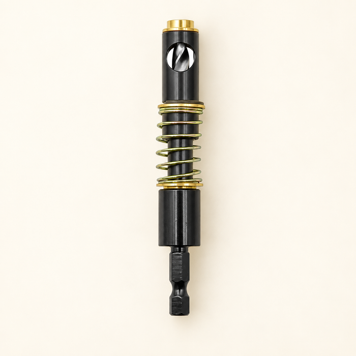Black and gold spring-loaded hinge drill bit on ivory surface