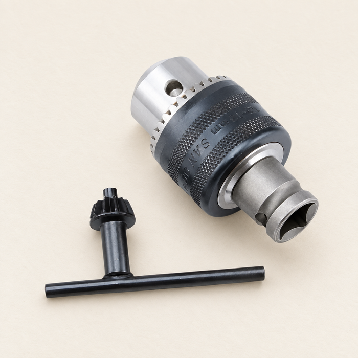 Drill chuck converter with a separate black T-shaped key on an ivory surface