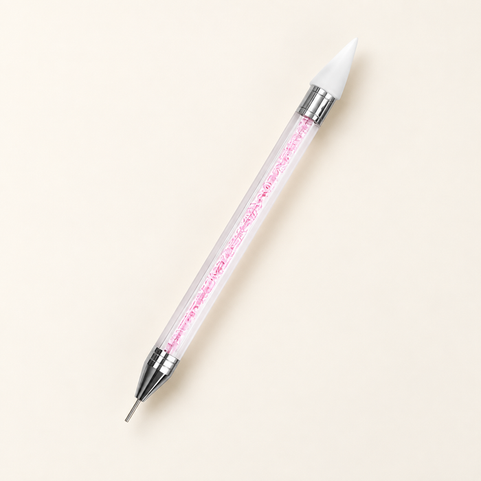 Pink crystal-filled double-ended nail pen on ivory surface