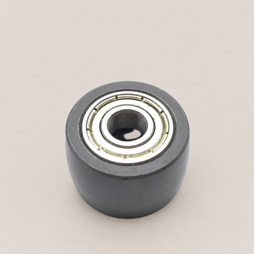 Small dark roller with a metal bearing on an ivory workbench.