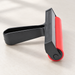 Red rubber roller with black handle on an ivory worktable