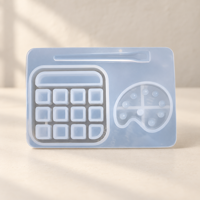 Translucent silicone mold with rectangular and palette-shaped cavities on an ivory worktable.