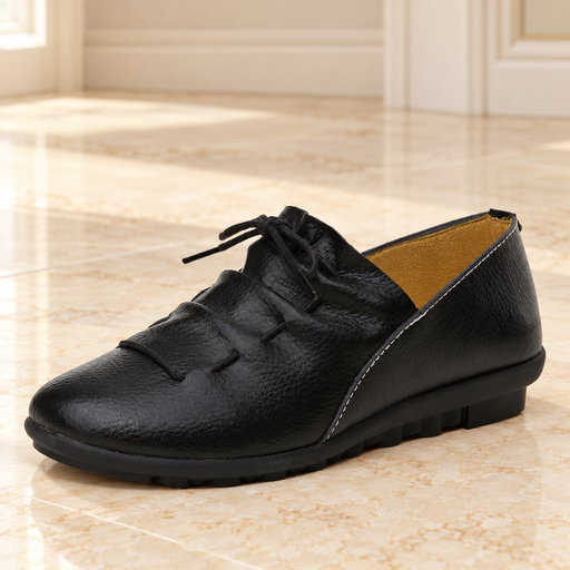 Black lace-up shoe with tan lining on pale ivory stone.