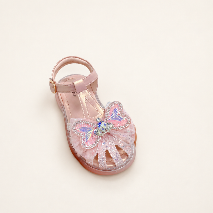 Pink butterfly sandal with sparkling embellishments and a buckle strap on an ivory surface.