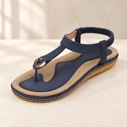 Navy and tan sandal with gold ring detail on an ivory surface