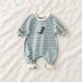 Green and white striped baby jumpsuit with a small dinosaur motif