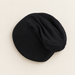 Black soft baby beanie on ivory tabletop