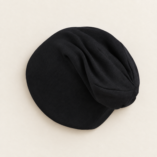 Black soft baby beanie on ivory tabletop