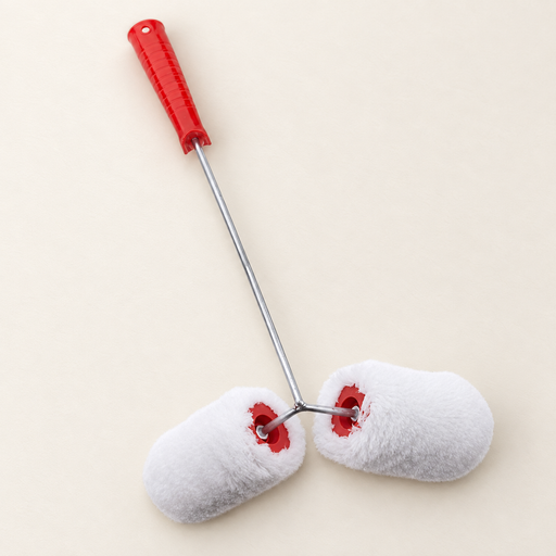 Double white paint roller with red handle resting on ivory worktable
