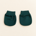 Pair of forest green baby mittens on ivory tabletop