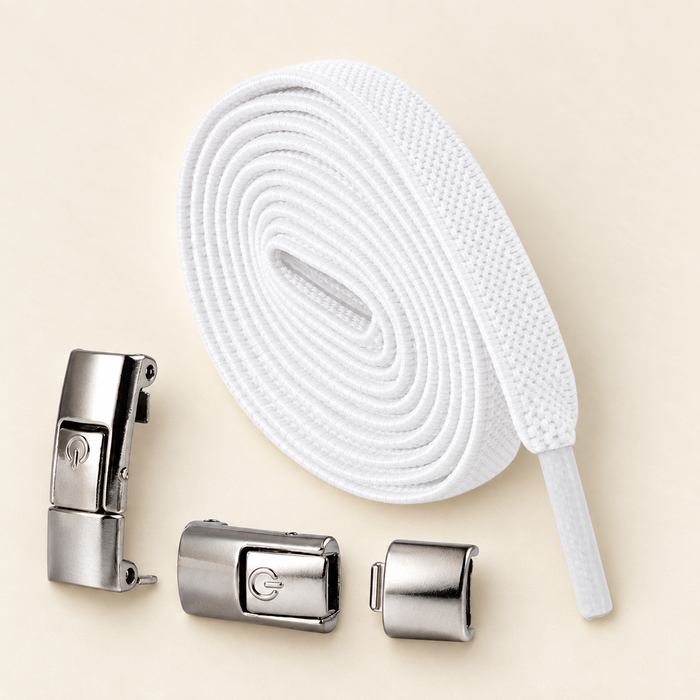 White elastic shoelace and silver fasteners on ivory tabletop