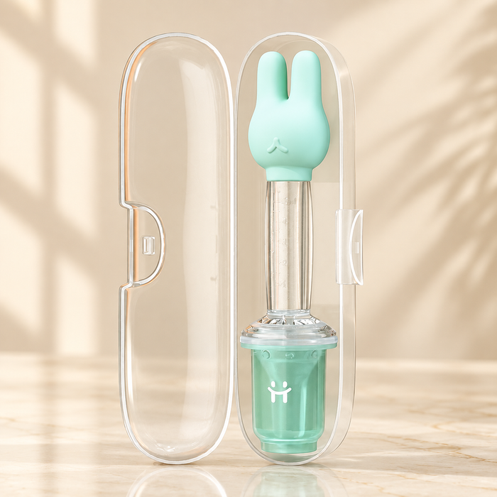 Mint rabbit feeding dispenser in open clear case on ivory surface