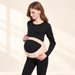 Beige prenatal support belt worn over black clothing against ivory background